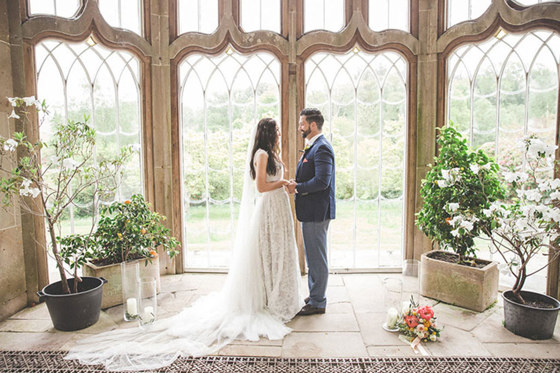 Bride and groom hold hands in Camellia House